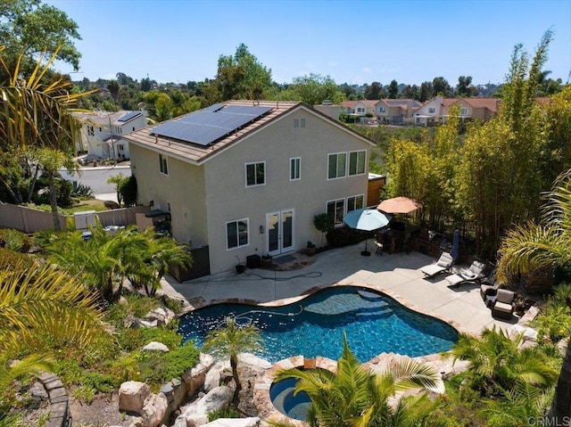 1905 Oxford Ct, Vista, CA 92081 - rear view of property featuring roof mounted solar panels, stucco siding, a patio area, a fenced backyard, and an outdoor pool