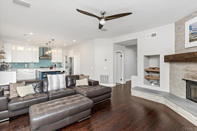 1905 Oxford Ct, Vista, CA 92081 - living area featuring ceiling fan, built in features, dark wood-style flooring, a stone fireplace, and recessed lighting