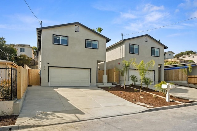 view of front of property featuring fence, a garage, driveway, and stucco siding