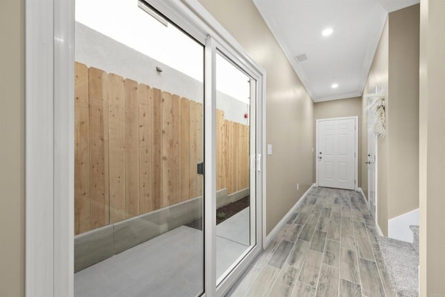 hallway with visible vents, baseboards, ornamental molding, recessed lighting, and wood finished floors