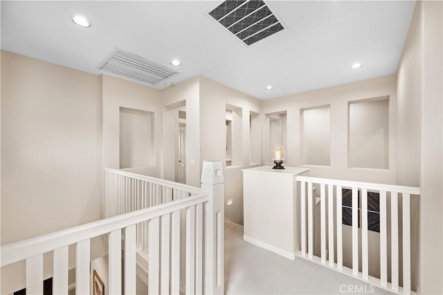 hallway featuring recessed lighting, visible vents, and an upstairs landing