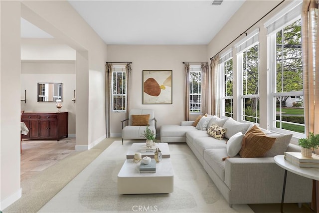 living room featuring light colored carpet and baseboards