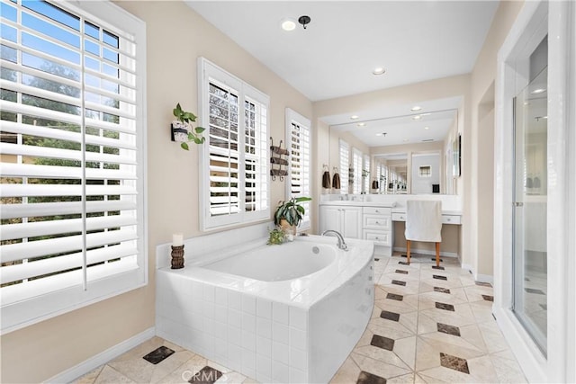 bathroom featuring baseboards, plenty of natural light, a bath, and a shower stall