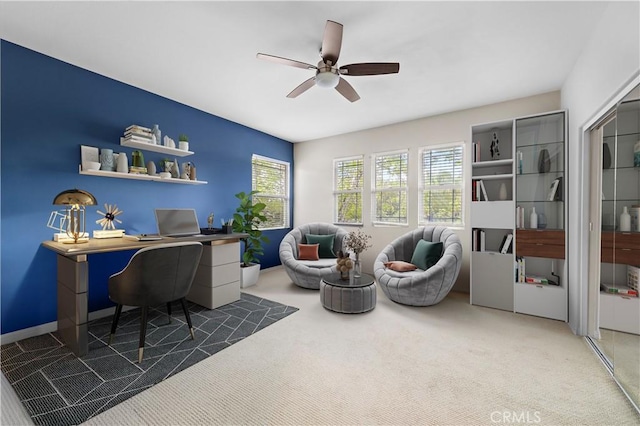 carpeted home office with baseboards and ceiling fan