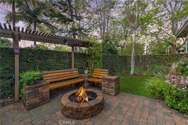 view of patio / terrace with fence, a fire pit, and a pergola