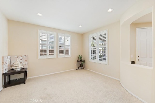 sitting room featuring arched walkways, recessed lighting, baseboards, and carpet floors