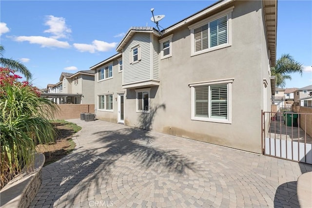 back of property with a patio area, a residential view, stucco siding, and fence