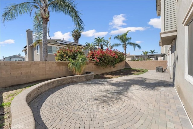 exterior space featuring a fenced backyard, cooling unit, and a patio