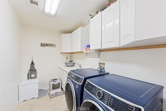 clothes washing area with visible vents, a sink, cabinet space, light tile patterned flooring, and washing machine and clothes dryer