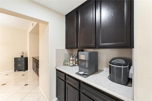 kitchen with light tile patterned floors, baseboards, and tasteful backsplash