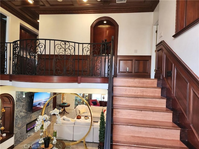 staircase with wainscoting and crown molding