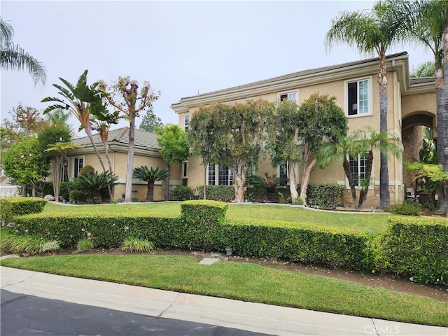 view of front of house featuring stucco siding and a front yard