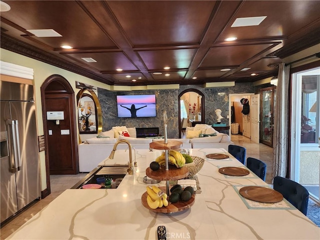 interior space with ornamental molding, coffered ceiling, recessed lighting, arched walkways, and a fireplace