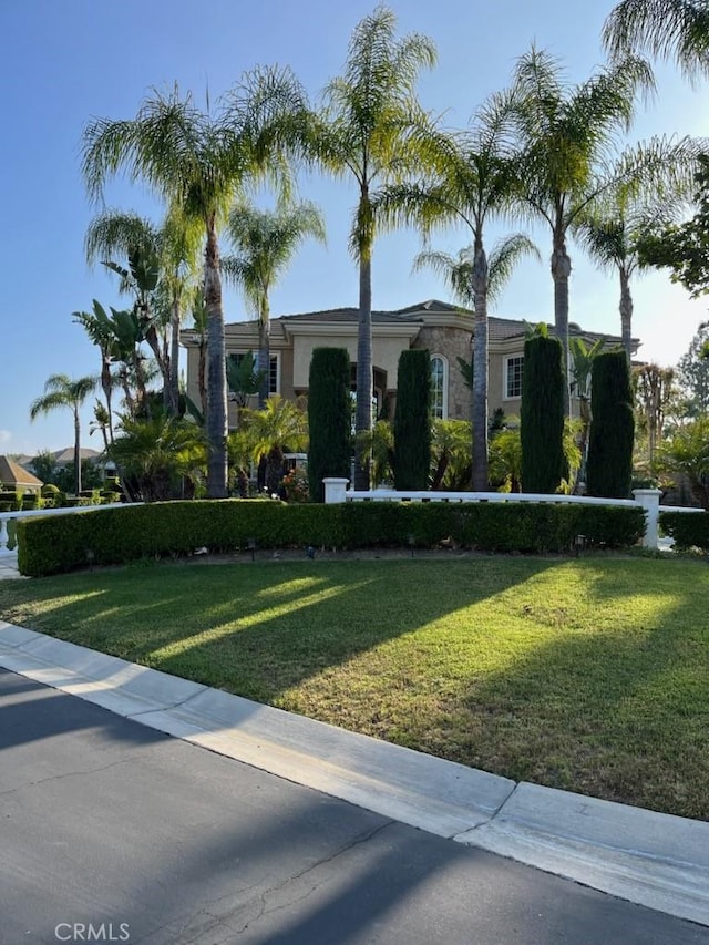 view of front of property featuring stucco siding and a front yard