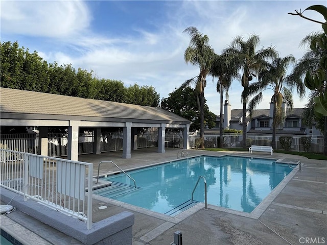 community pool featuring a patio area and fence