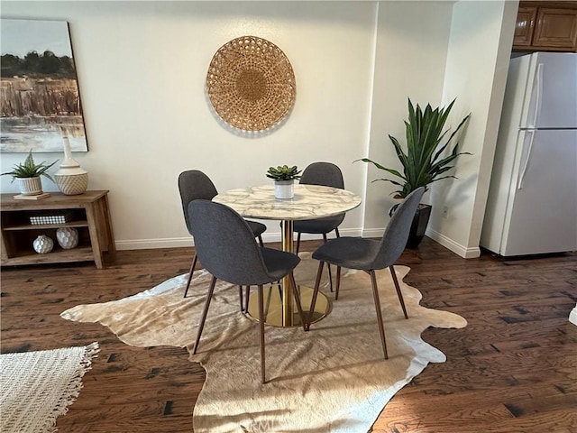 dining area featuring wood finished floors and baseboards