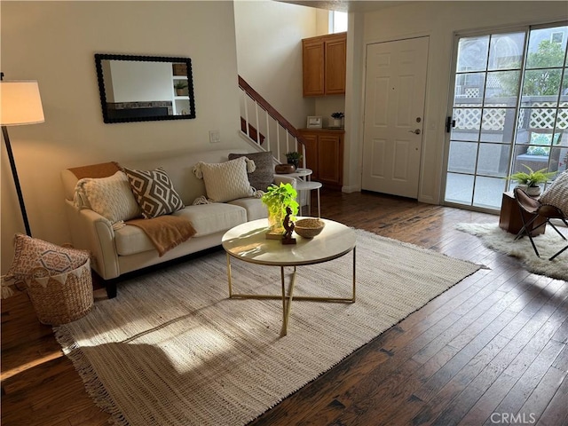 living area with stairs and dark wood-type flooring