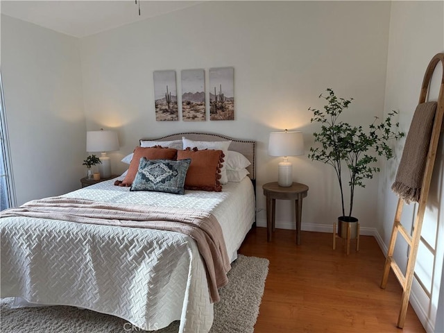 bedroom featuring baseboards and wood finished floors