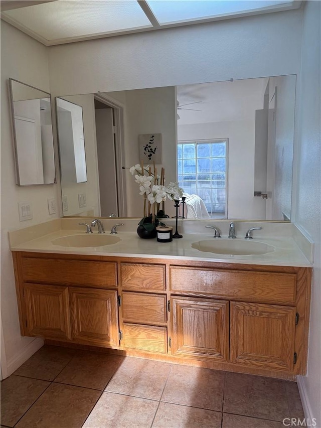 ensuite bathroom with tile patterned flooring, double vanity, and a sink