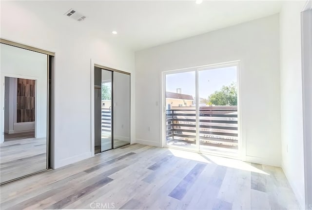 spare room featuring visible vents, recessed lighting, and wood finished floors