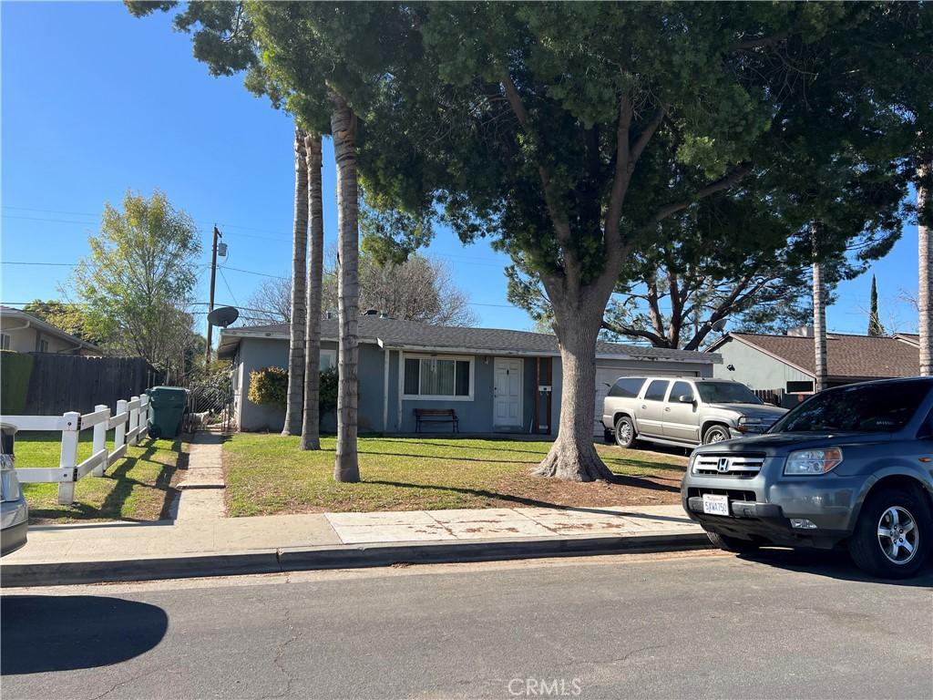 ranch-style home with a front yard and fence