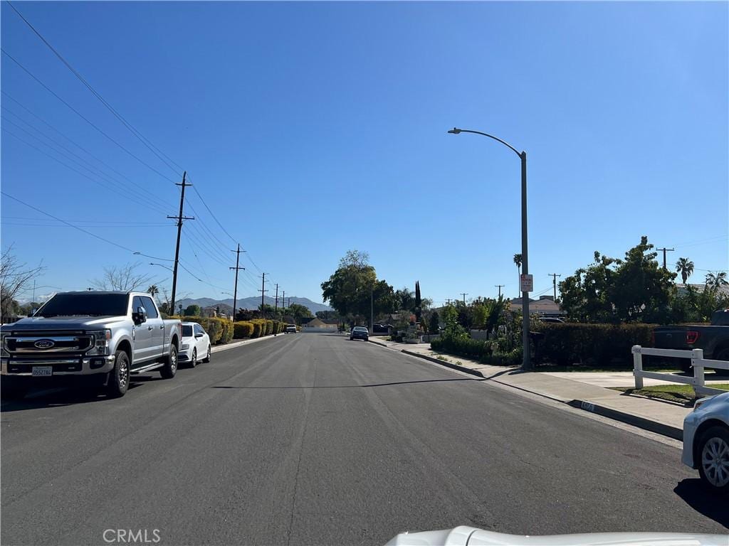 view of road with street lights, curbs, and sidewalks