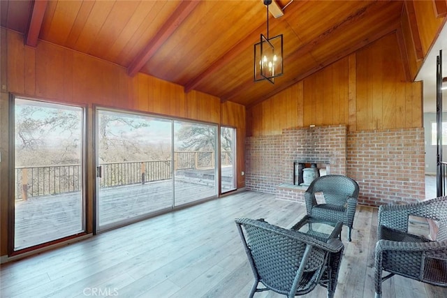 sunroom / solarium with wooden ceiling, lofted ceiling with beams, and an inviting chandelier