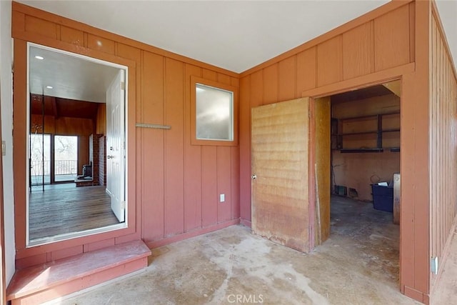 empty room with wooden walls and concrete floors