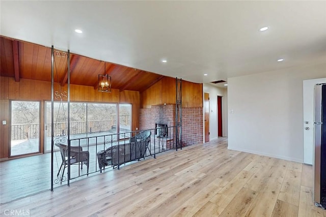 interior space featuring a brick fireplace, recessed lighting, a healthy amount of sunlight, and light wood finished floors