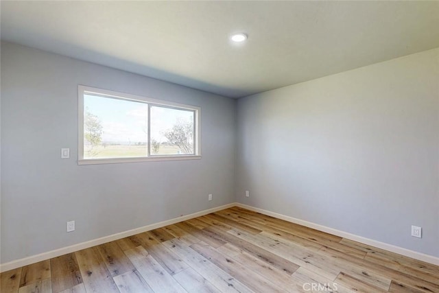 unfurnished room featuring baseboards and wood-type flooring