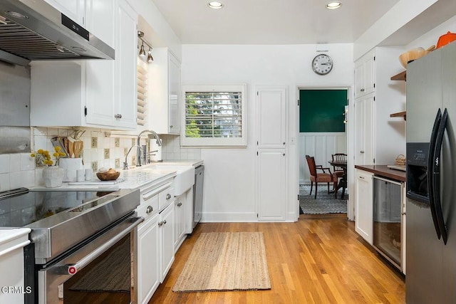 kitchen with wine cooler, white cabinetry, ventilation hood, and stainless steel appliances