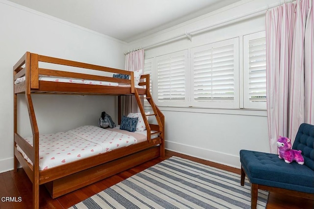 bedroom featuring wood finished floors, baseboards, and ornamental molding