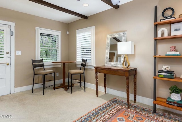 dining room featuring beamed ceiling, baseboards, and carpet