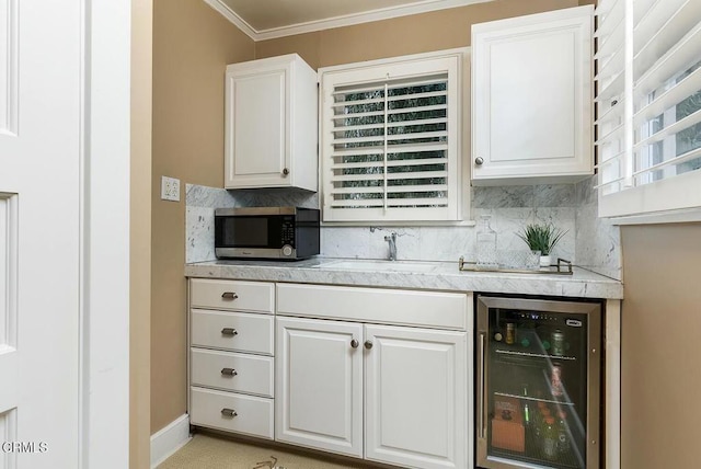 kitchen featuring tasteful backsplash, stainless steel microwave, beverage cooler, light countertops, and white cabinets