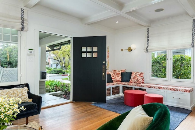 living room featuring a wealth of natural light, beamed ceiling, and wood finished floors