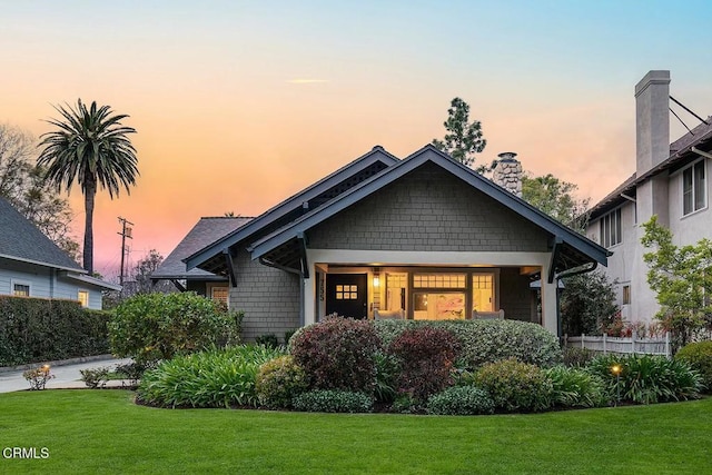 craftsman-style home featuring a front lawn and a chimney