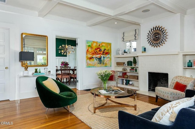 living area featuring beam ceiling, coffered ceiling, and wood finished floors