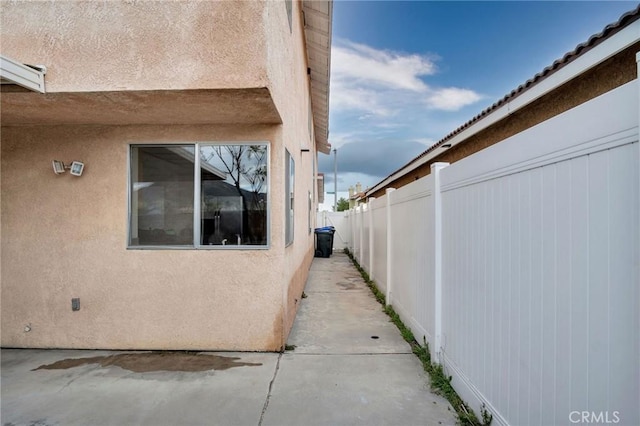 view of property exterior featuring stucco siding and fence