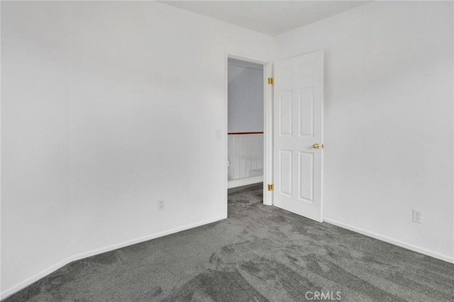 carpeted spare room featuring baseboards