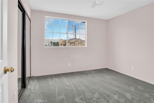 unfurnished bedroom featuring a closet, baseboards, ceiling fan, and carpet flooring