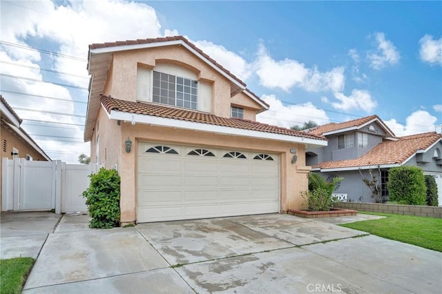 view of front of house featuring a gate, stucco siding, driveway, and a tile roof