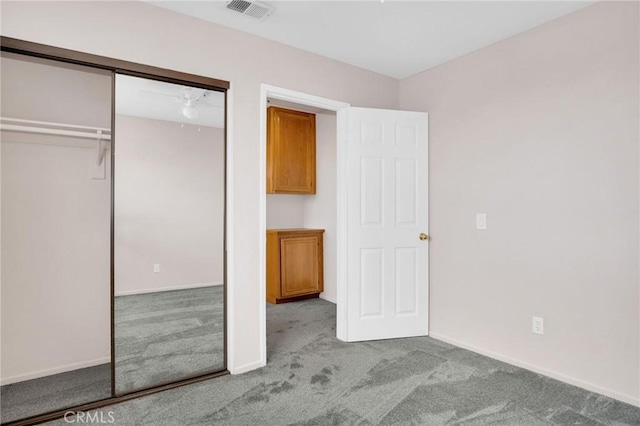 unfurnished bedroom with a closet, baseboards, visible vents, and carpet floors