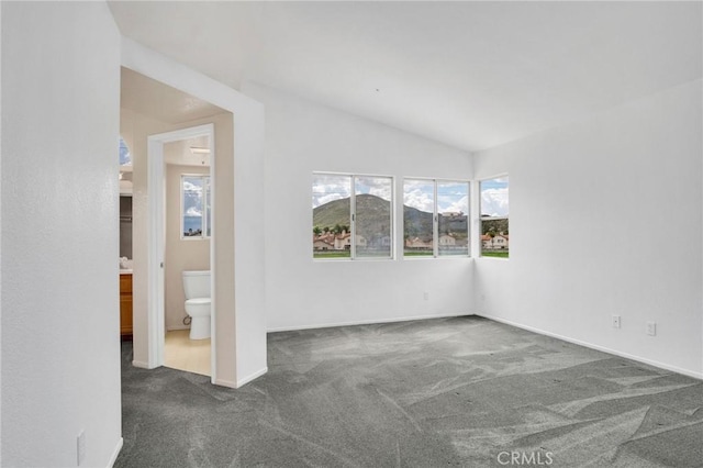 empty room with baseboards, carpet, and vaulted ceiling