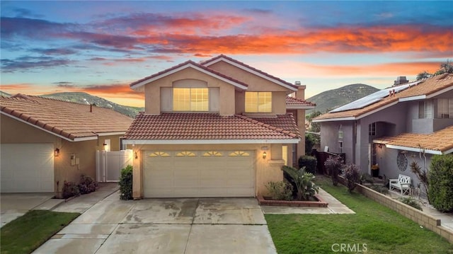 traditional-style house with stucco siding, a tile roof, and a garage