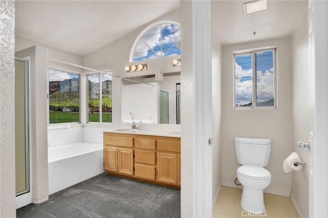 bathroom featuring double vanity, a garden tub, toilet, and a shower stall