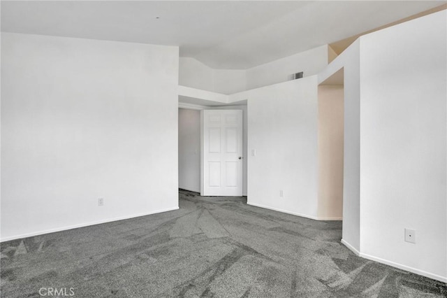 spare room with visible vents, baseboards, carpet, and vaulted ceiling