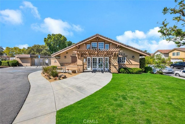 view of front of property with stucco siding, concrete driveway, a pergola, and a front yard