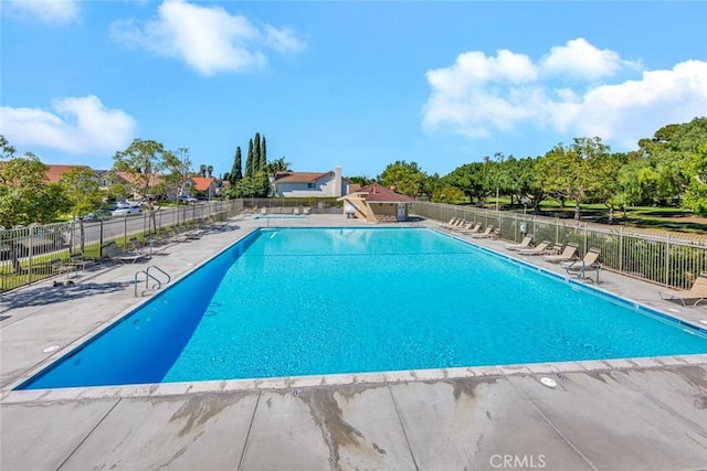 community pool featuring a patio area and fence