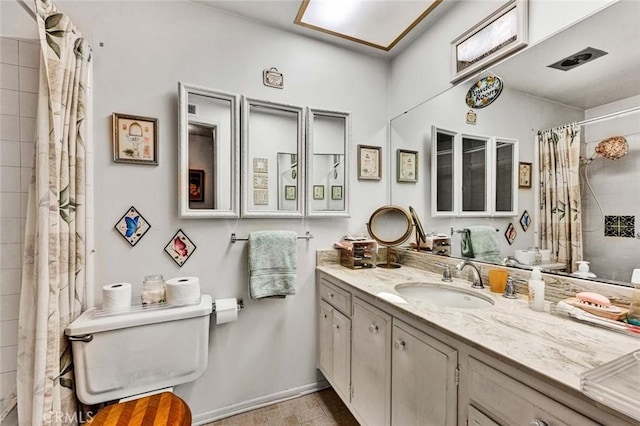 full bath featuring a shower with shower curtain, baseboards, toilet, and vanity