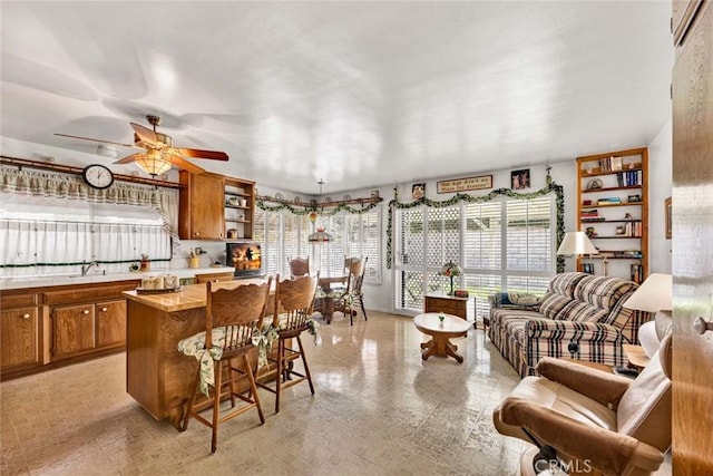 kitchen with butcher block countertops, light floors, a kitchen bar, brown cabinets, and open shelves